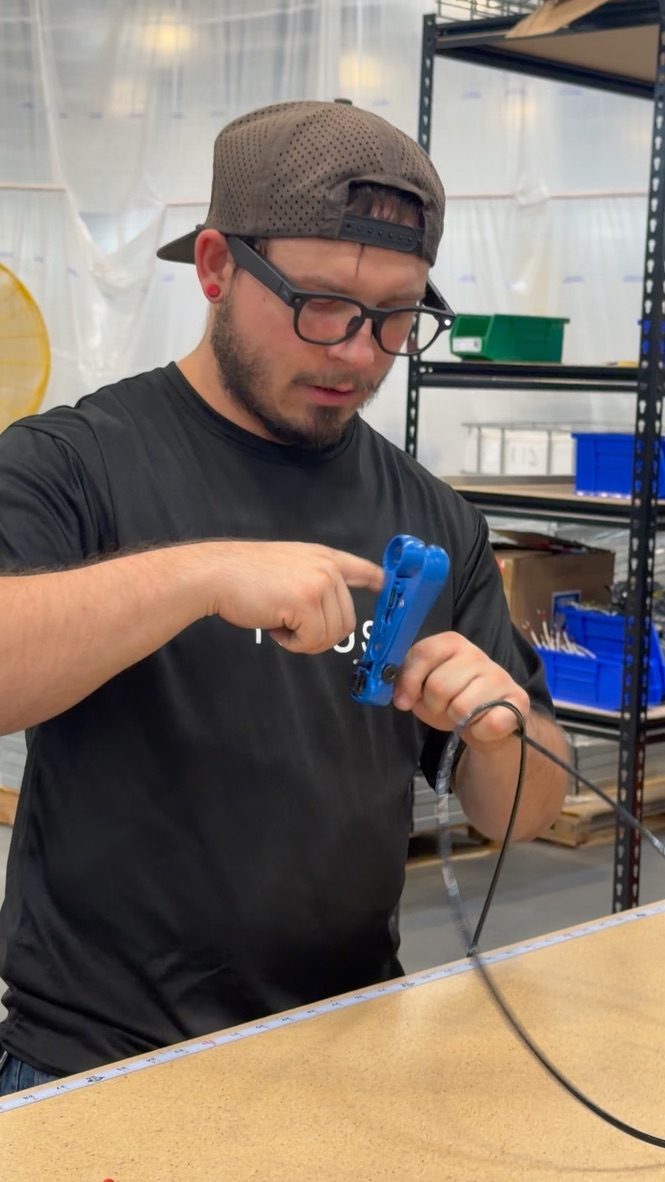 Operator wearing smart glasses while demonstrating a task at a bench